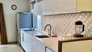 Eine moderne Küche mit eingebauter Waschmaschine, Spüle und Kaffeemaschine.