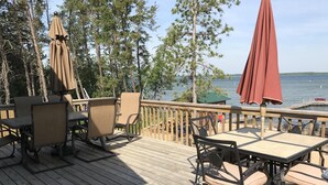 A wooden deck with outdoor seating, overlooking a body of water. - *HIGH DEMAND* Sugar Sand Beach & Cozy Cabin That Sleeps 10 on Pelican Lake!  (Merrifield)