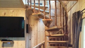 A spiral wooden staircase in a cabin with a television mounted on the wall. - *HIGH DEMAND* Sugar Sand Beach & Cozy Cabin That Sleeps 10 on Pelican Lake!  (Merrifield)