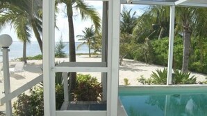 A poolside area with a clear view of the beach and ocean. - The Pools #1- the Luxury Beachfront Hideaway with Private Pool (North Side, Cayman Kai,)
