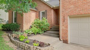A two-story brick house with a front porch, a garage, and a landscaped garden. - Renovated Home in Downtown Historic Franklin Close To Everything! (Franklin)