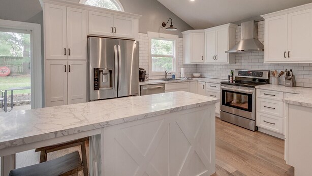 A modern kitchen with white cabinetry, stainless steel appliances, and a marble countertop. - Renovated Home in Downtown Historic Franklin Close To Everything! (Franklin)