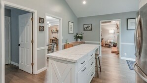 A spacious kitchen with a large island, wooden flooring, and a view into the dining area. - Renovated Home in Downtown Historic Franklin Close To Everything! (Franklin)