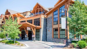 A modern building with a reception area, large windows, and a stone facade. - Mountain Views - Canmore Luxury Condo in Solara Resort - Steps to restaurants (Canmore)
