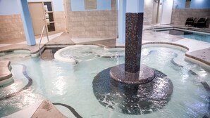 A swimming pool with a central column and a fountain. - Mountain Views - Canmore Luxury Condo in Solara Resort - Steps to restaurants (Canmore)