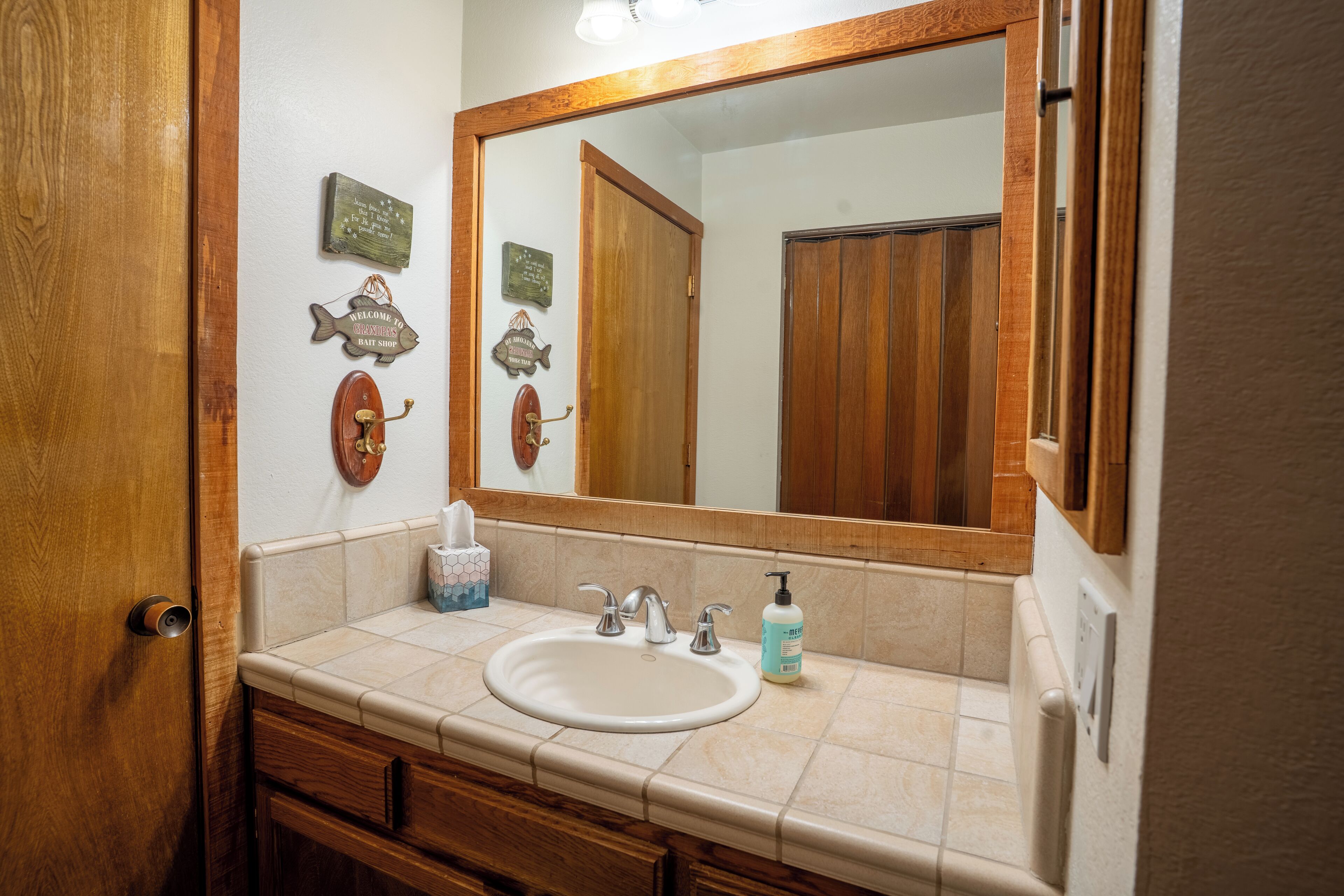 Une salle de bain avec un meuble-lavabo en bois, un grand miroir et un lavabo.