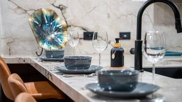 Een moderne keuken met een marmeren aanrechtblad, een zwarte kraan en een decoratief glazen object.