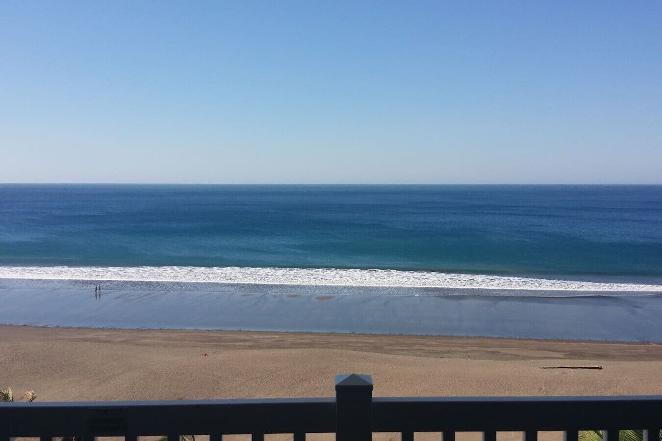 Una playa con vista clara al océano y una orilla arenosa.