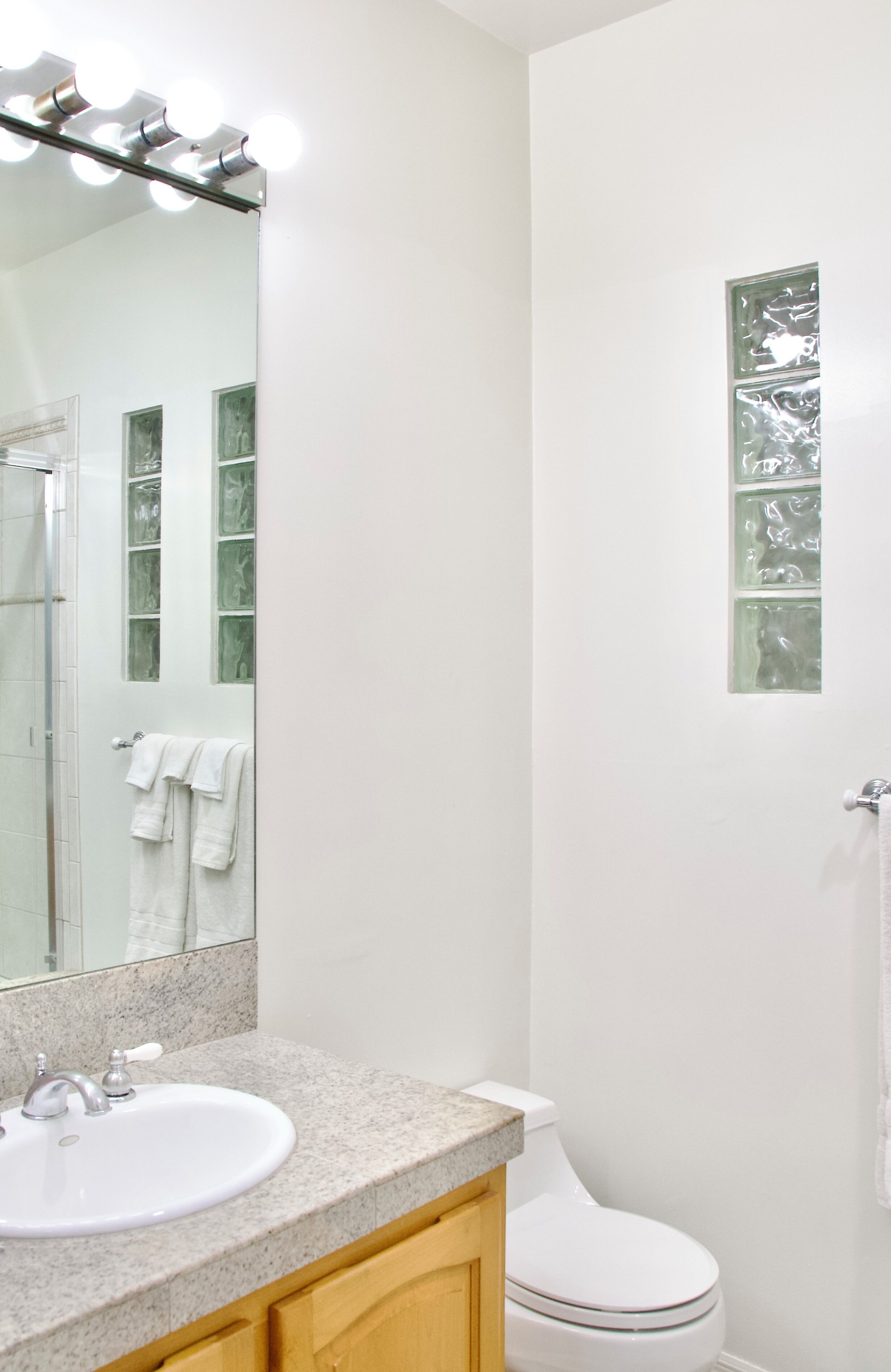 A bathroom with a sink, mirror, and toilet.