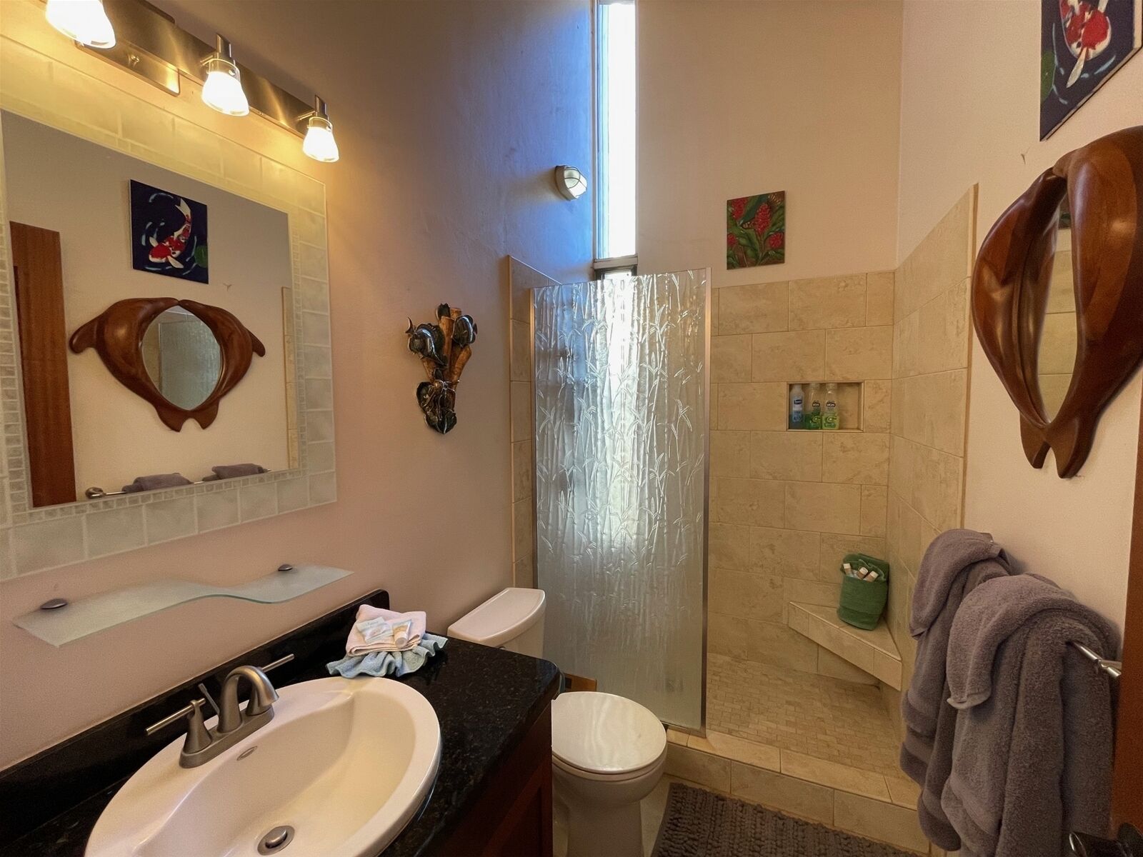 Ein Badezimmer mit Waschbecken, Spiegel, Dusche und Toilette.