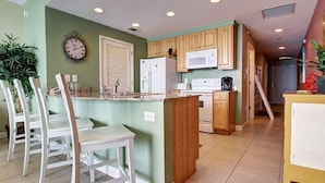 Una cocina compacta con una isla central, armarios de madera y electrodomésticos modernos.