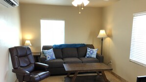 A living room with a leather chair, a sofa with patterned cushions, a wooden coffee table, a floor lamp, and a ceiling fan. - Clean, renovated 1 Bedroom with everything you need. Granite, Travertine! (Tucson)