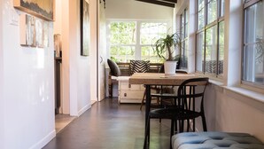 A spacious kitchen with a dining area, large windows, and a modern design. - Chic Apartment-Style Suite, Steps From Main, Luxury Finishings, Outdoor Shower (Fredericksburg)