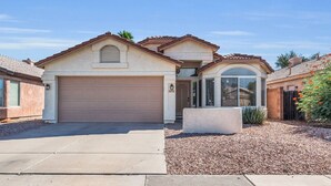 A two-story house with a garage, a covered entryway, and a landscaped driveway. - Old Town Scottsdale oasis with resort style back yard!!! (Scottsdale)