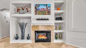 A modern living room with a fireplace, white shelving, and decorative items. - Old Town Scottsdale oasis with resort style back yard!!! (Scottsdale)
