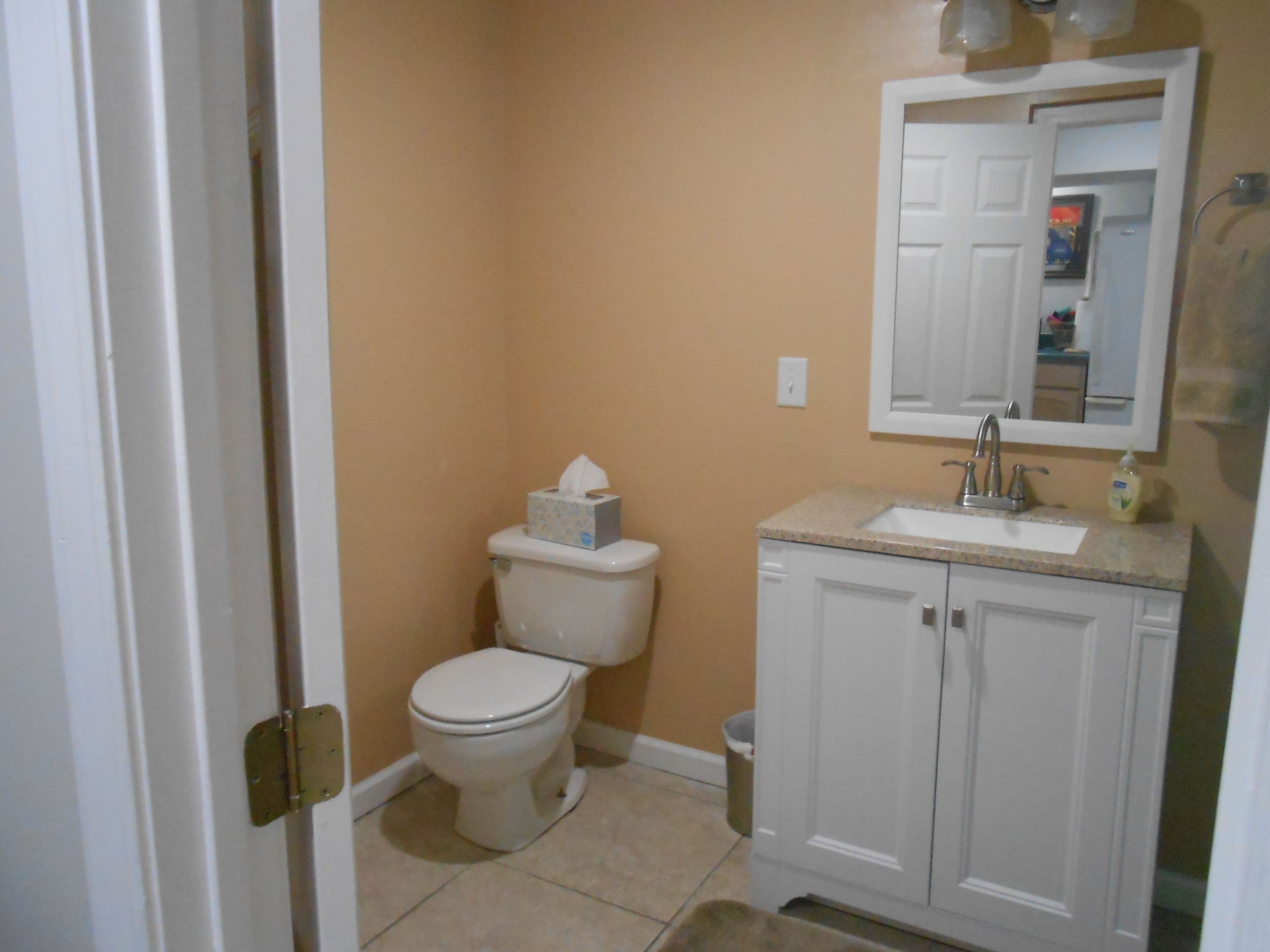 Un baño pequeño con inodoro, lavamanos y mueble.