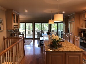 Enjoy cooking in this well-equipped kitchen with a central island, oven, and large window offering a view of the outdoors.