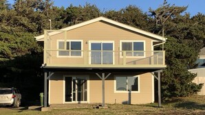 A two-story house with a balcony, a garage, and a driveway. - Sue's Dream with Beautiful Ocean Views (Florence)