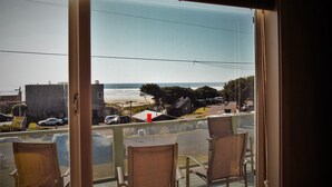 A balcony with chairs overlooking a beach and street view. - Sue's Dream with Beautiful Ocean Views (Florence)