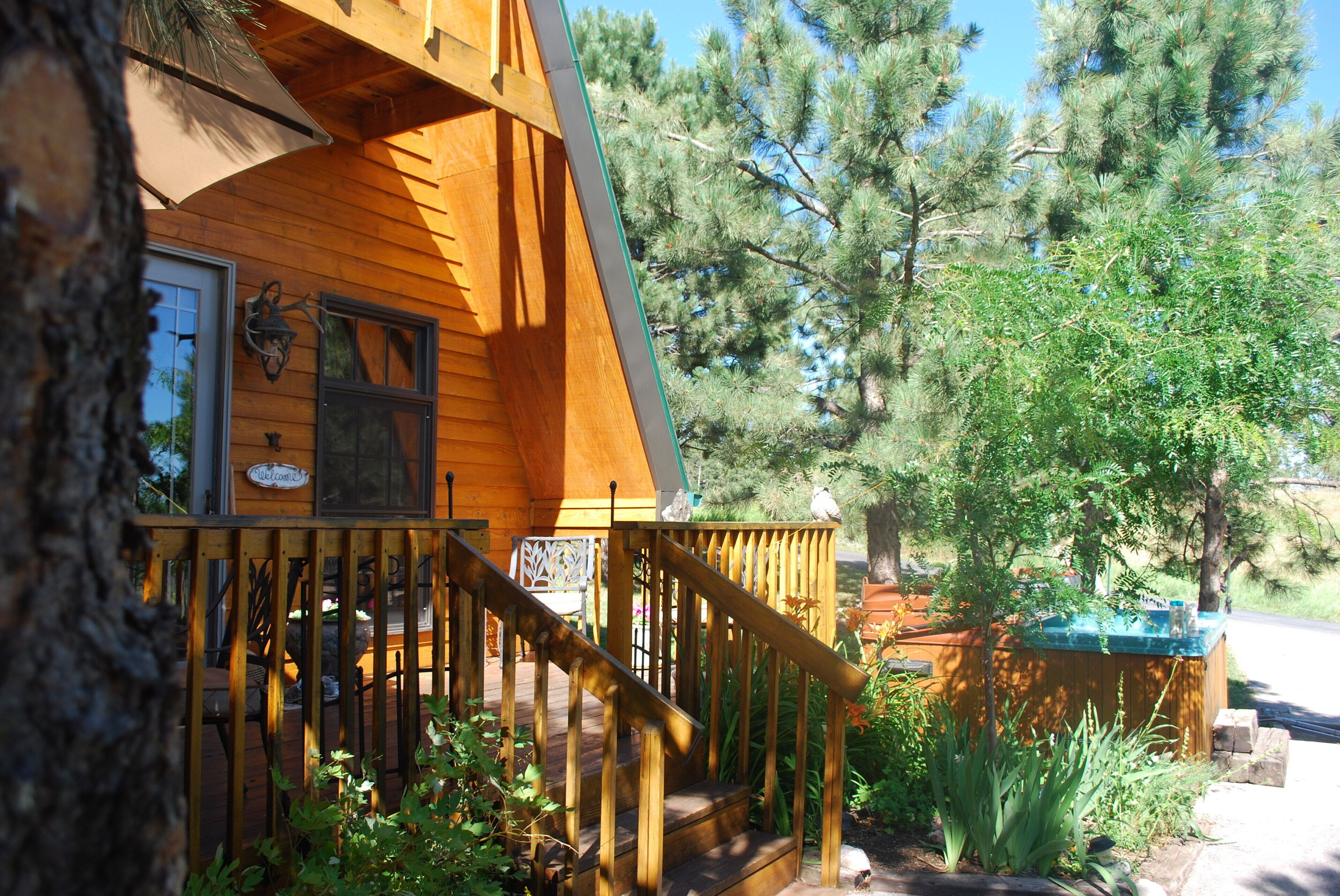A wooden cabin with a wooden staircase leading to a deck.