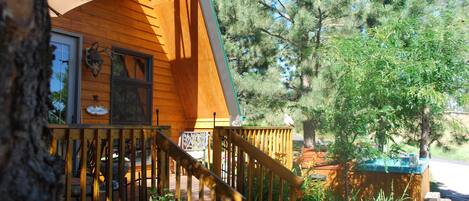 A wooden cabin with a wooden staircase leading to a deck.
