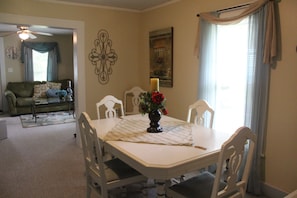 Enjoy meals in this dining area with a table for four, surrounded by comfortable chairs and a beautiful floral arrangement.