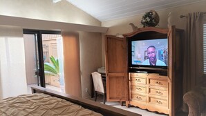 A bedroom with a bed, a wooden dresser, a television, and a window with curtains. - Beautiful Oceanfront Home, Gorgeous Views, Deck and Patio! Best Value! (Encinitas)