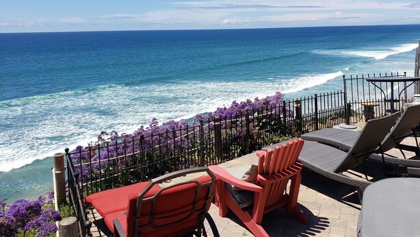 A patio with outdoor seating, a view of the ocean, and a fence with purple flowers. - Beautiful Oceanfront Home, Gorgeous Views, Deck and Patio! Best Value! (Encinitas)
