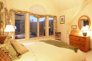 Relax in this inviting bedroom with a large bed, wooden dresser, and mirror.