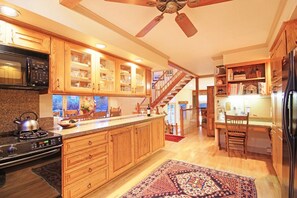 Kitchen with central island, microwave, and large window.