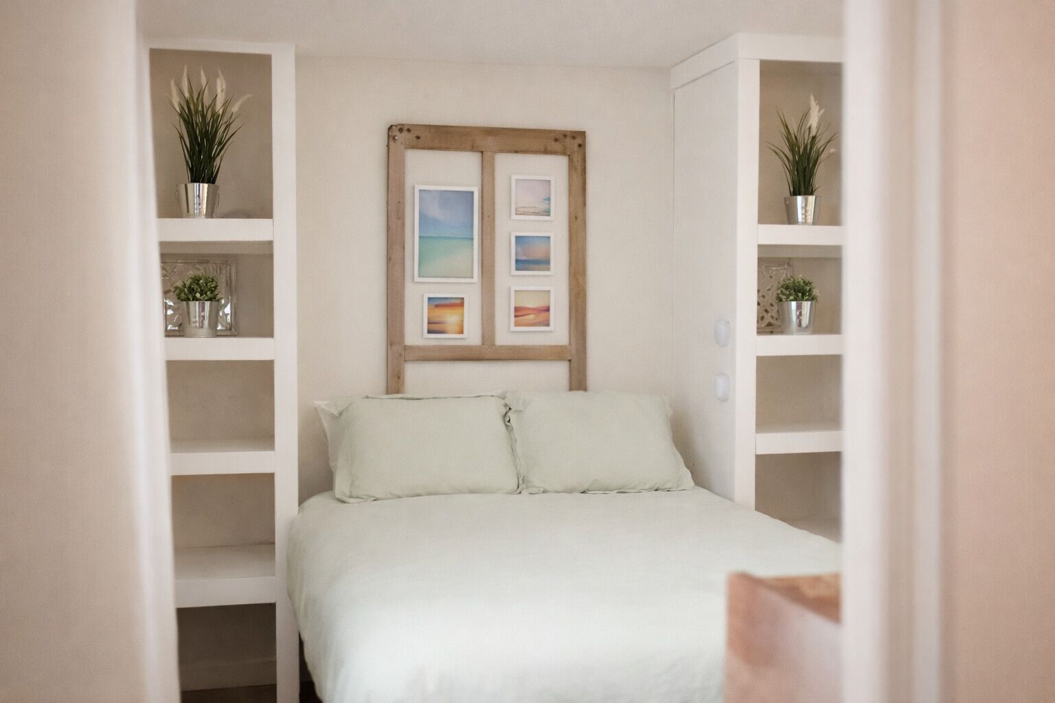A bedroom with a bed, a wooden headboard, and shelves with plants.