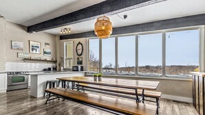 A spacious kitchen with a large island, wooden bench, and a hanging light fixture. - Mountain View Blue Mountain (Blue Mountains)