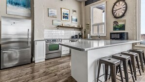 A modern kitchen with a large island, stainless steel appliances, and bar stools. - Mountain View Blue Mountain (Blue Mountains)