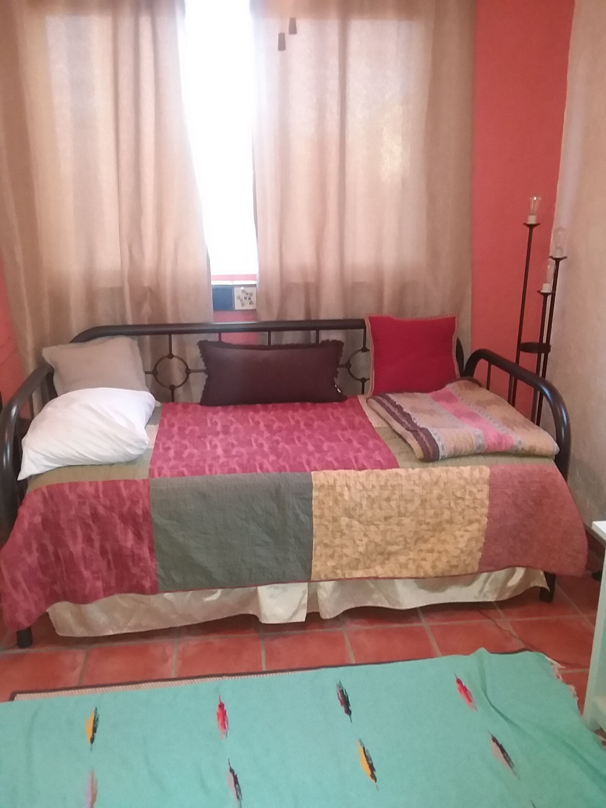 Un lit avec un cadre en métal, une couette et deux oreillers.