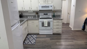 A kitchen with white cabinets, a built-in oven, and a microwave. - SEPTEMBER BEACH TIME... NO CROWDS..LOW PRICES! (Gulf Shores)