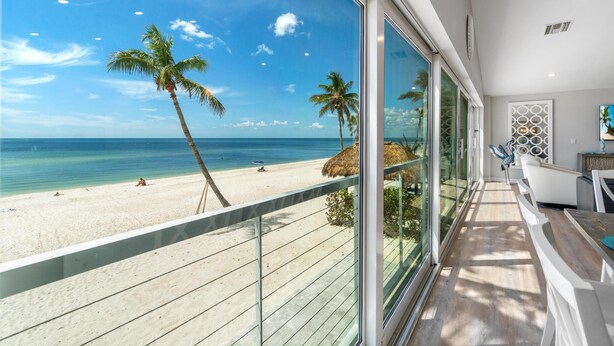 Un balcon avec vue sur une plage et l’océan.