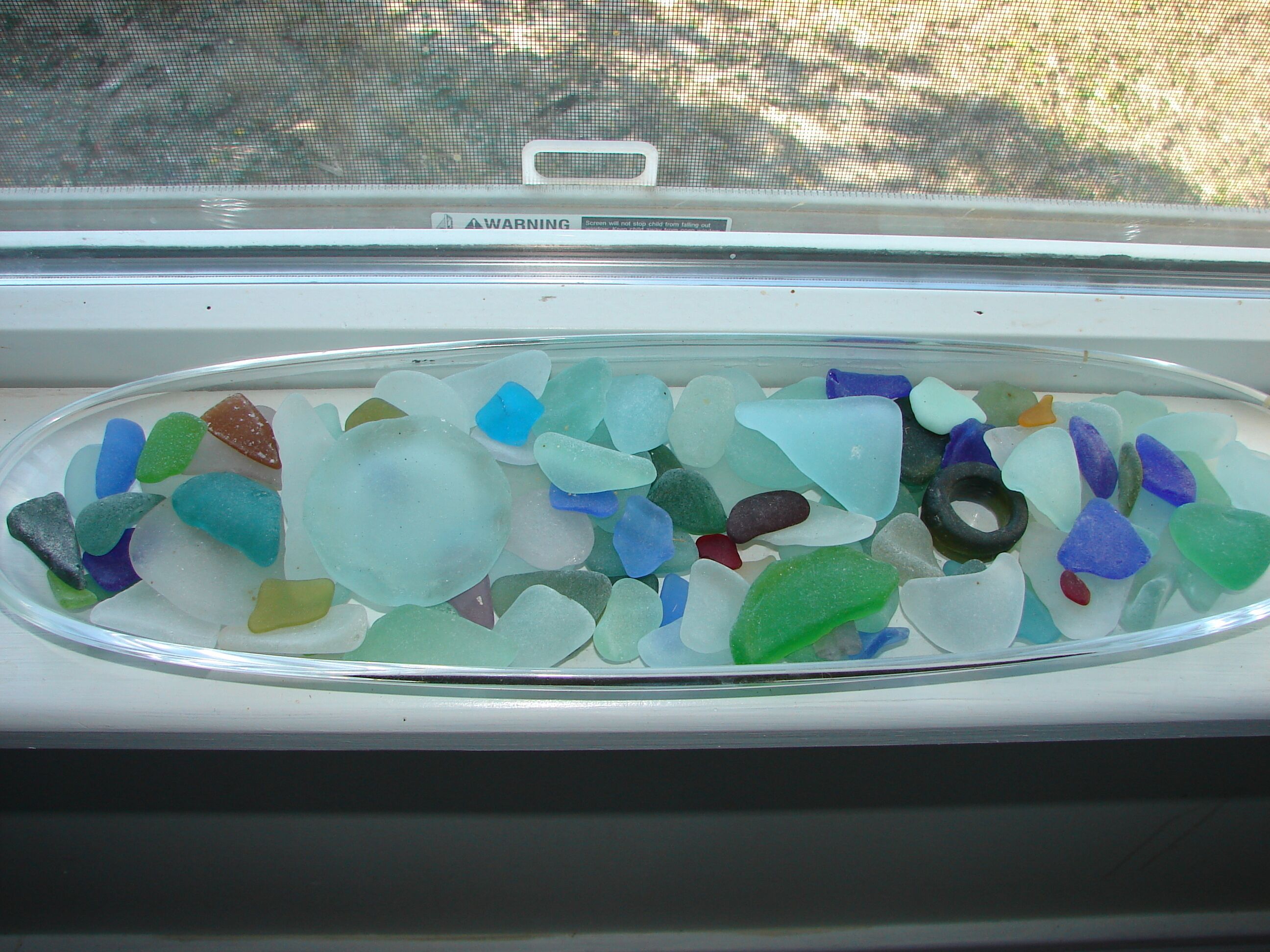 A window with a collection of colorful glass pieces.
