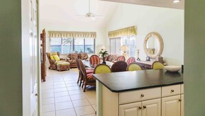 A spacious living area with a dining table, multiple chairs, and a kitchen counter.