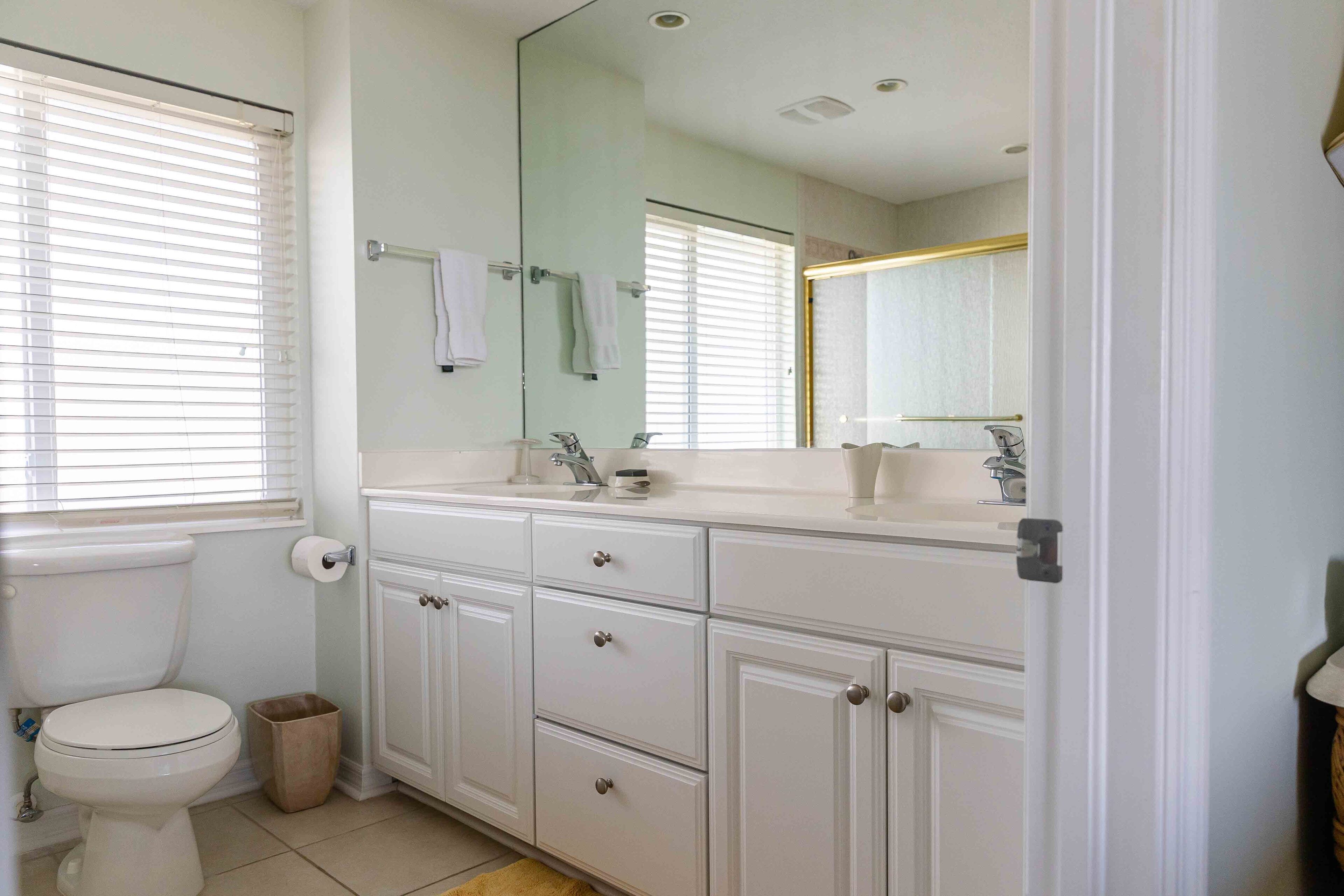 Une salle de bain avec des toilettes, un lavabo et un miroir.