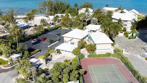 A coastal hotel with a tennis court, parking, and views of the ocean.