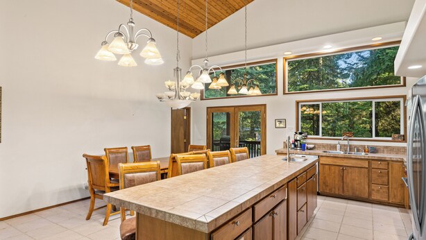 A modern kitchen with wooden cabinets, a large island, and pendant lighting. - Elk Tracks Lodge (Easton)