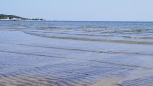 Ein Strand mit sanften Wellen und blauem Himmel.