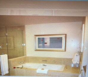 A bathroom with a glass shower enclosure, a sink with a mirror, and a towel rack.