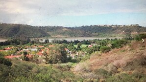 A rural landscape with a river, houses, and hills. - Four Season Aviara                            (Carlsbad)