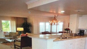 A spacious living area with a large island, a chandelier, and a view of the outdoors. - Four Season Aviara                            (Carlsbad)