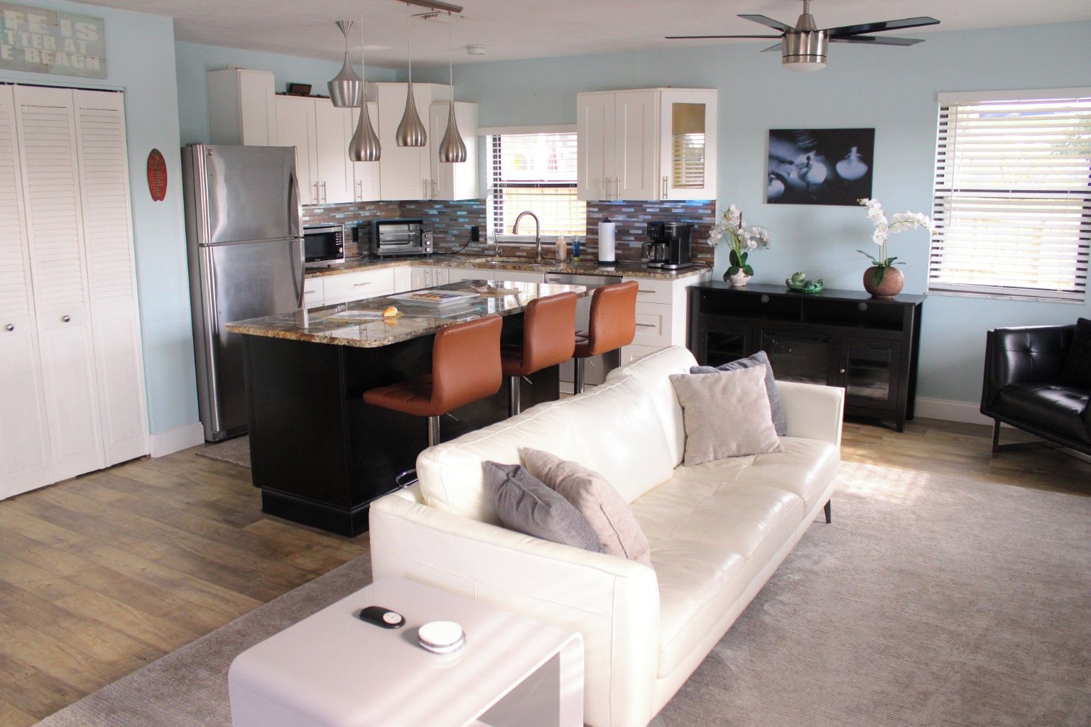 A modern kitchen with a central island, white cabinets, and stainless steel appliances.