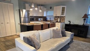 A modern kitchen with white cabinets, stainless steel appliances, and a central island.