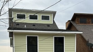 Un bâtiment à deux étages, doté d’un toit plat, de grandes fenêtres et d’un numéro de maison bien visible.