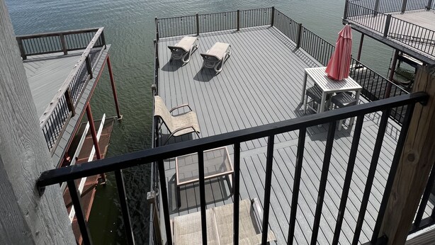 Une terrasse avec des sièges extérieurs et une vue sur une étendue d’eau calme.
