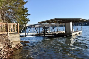 A dock extending into a lake with a wooden walkway and a covered area. - Country Cottage, near HaHa Tonka Park, Free Kayaks & Outdoor Pavilion Game room (Camdenton)